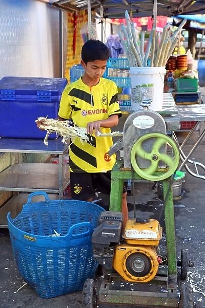 Boy making Durian juice in the street by squeezing the fruit, Yangon, Myanmar