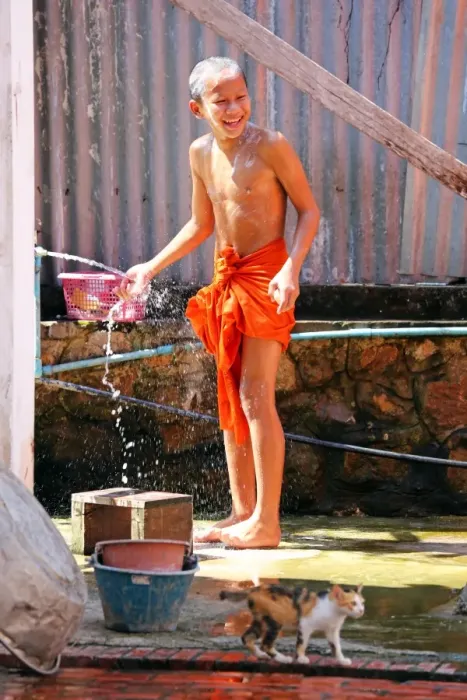  : Buddhist monk taking a shower at Vat Sop Sickharam temple, Luang Prabang, Laos