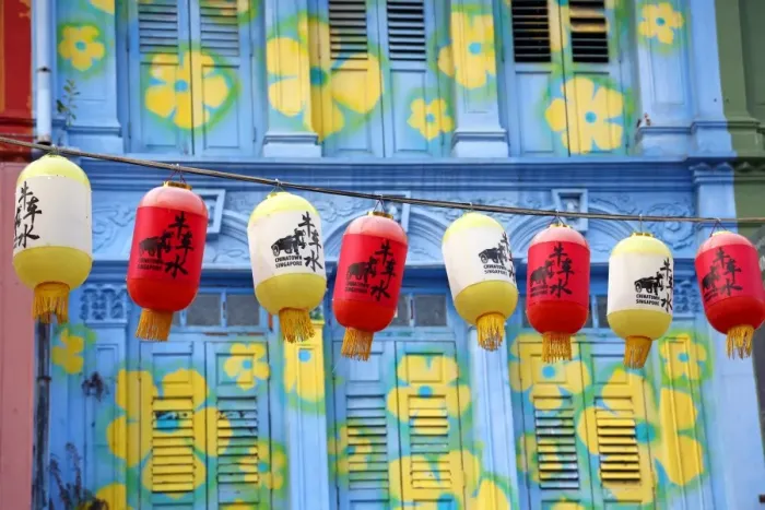 : Chinese lanterns hanging in front of colourful buildings with shutters and windows in Chinatown in Singapore, Republic of Singapore
