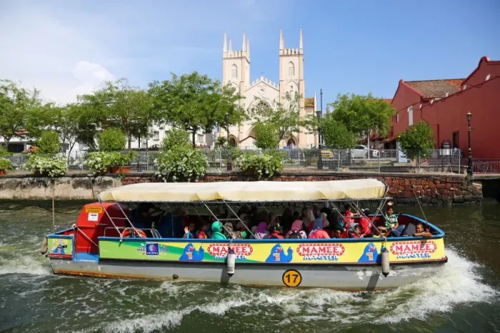  : Church of St. Francis Xavier and a tourist sightseeing boat on the Sungai Melaka river in Malacca, Malaysia