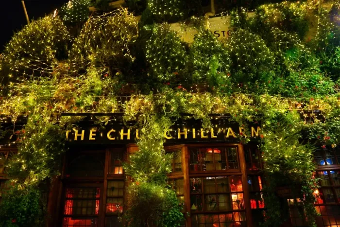  : Churchill Arms Pub covered in Christmas Trees in Kensington, London