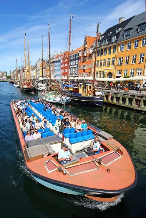  : Coloured houses and a tourist sightseeing tour boat at Nyhavn Quay in Copenhagen, Denmark