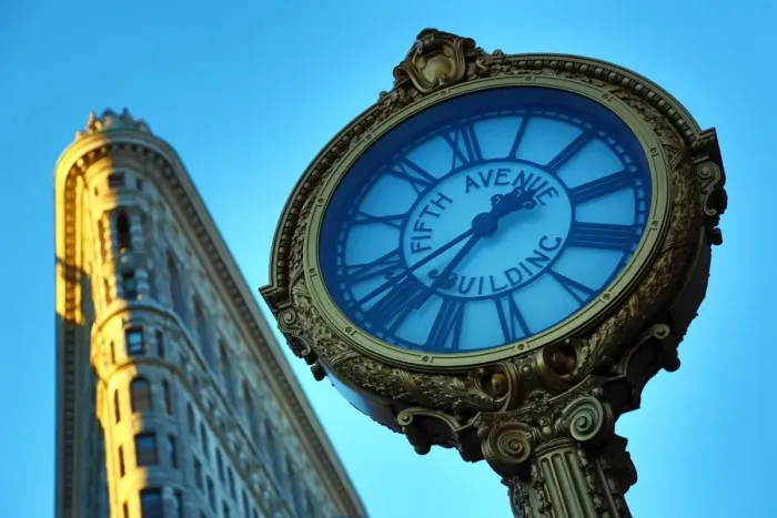  : The Flatiron Building, originally the Fuller Building, and Fifth Avenue Building clock at Fifth Avenue and Madison Square, New York. America
