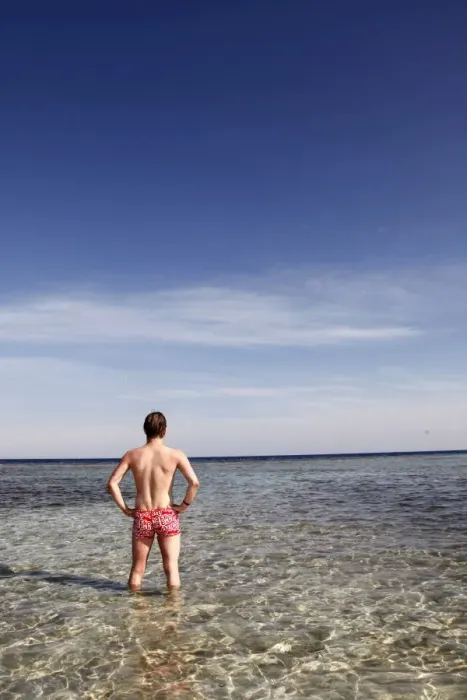  : Man standing in the sea looking at the horizon
