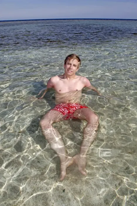  : Man on summer holiday relaxing and lying in the sea on the beach