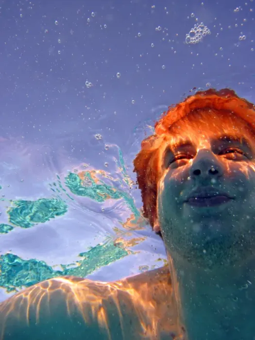 : Man swimming underwater surrounded by bubbles