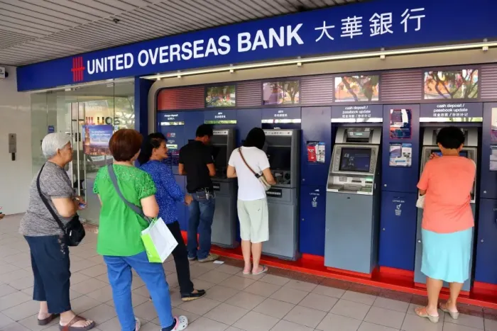  : People using the ATM cashpoint machines at the United Overseas Bank in Singapore, Republic of Singapore