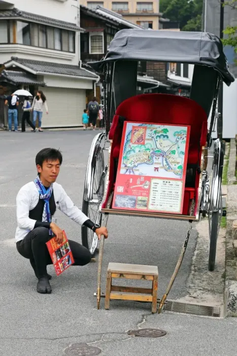  : A rickshaw and its driver at Itsukushima Shinto Shrine on Miyajima Island, Hiroshima, Japan