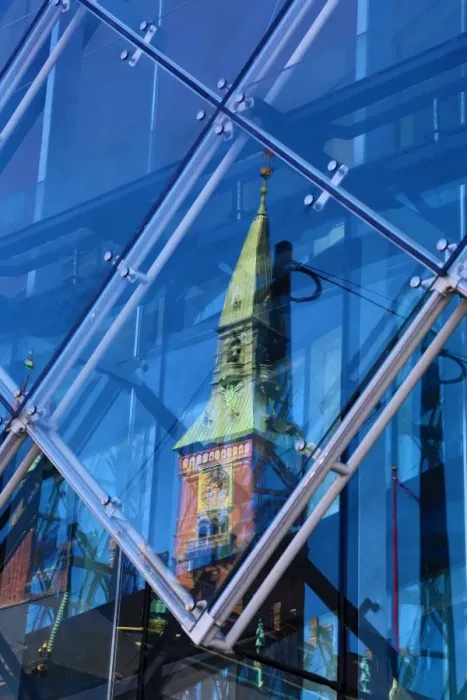  : Scandic Hotel clock tower reflected in a diamond shaped glass window in Copenhagen
