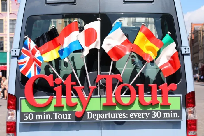  : Sign with international flags on a City Tour sightseeing bus, Bruges, Belgium