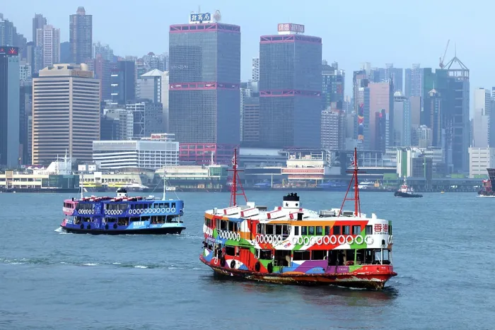  : Two Star Ferries crossing Victoria Harbour with the city skyline in Hong Kong, China