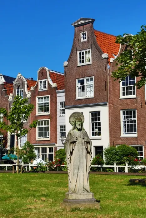  : Statue of Jesus Christ and traditional Dutch houses in Begijnhof in Amsterdam, Holland
