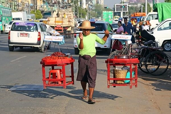 Street seller carrying wares on his shoulders, Yangon, Myanmar