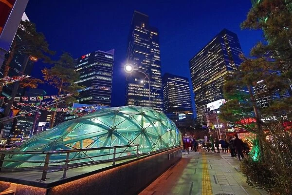Tall modern buildings and office blocks at dusk with the glass of Gangnam metro station