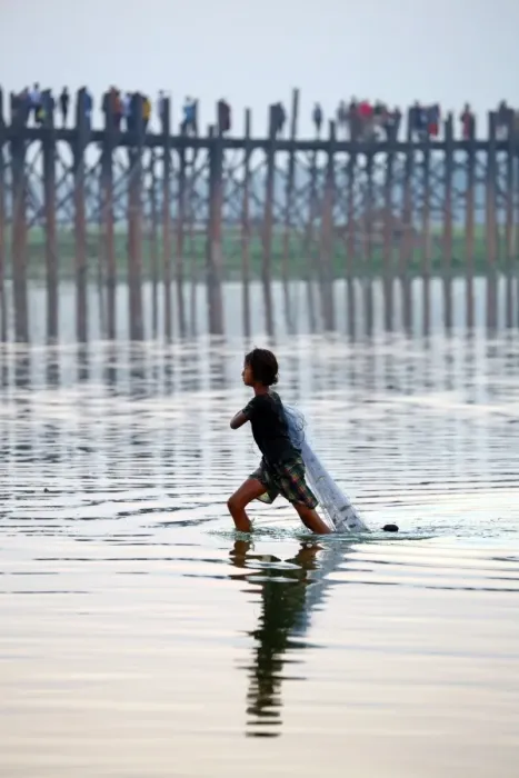  : The U Bein Bridge with a fisherman walking across the Taungthaman Lake in Amarapura