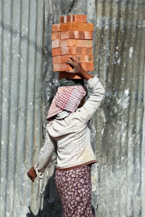  : Woman carrying bricks on her head on a building site in Amarapura, Mandalay, Myanmar