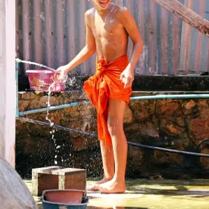 Buddhist monk taking a shower at Vat Sop Sickharam temple, Luang Prabang, Laos