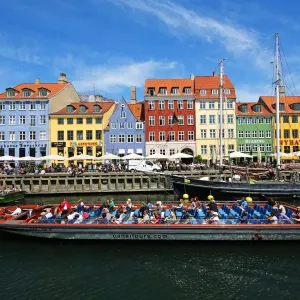 Coloured houses and a tourist sightseeing tour boat at Nyhavn Quay in Copenhagen, Denmark