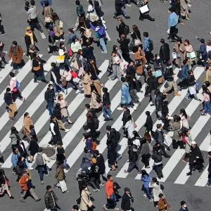Crowds crossing the Shibuya pedestrian crossing in Shibuya, Tokyo, Japan