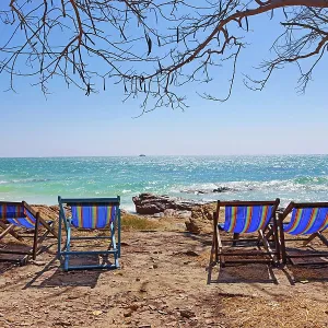 Deckchairs on Koh Samet beach overlooking the sea on Koh Samet island, Thailand