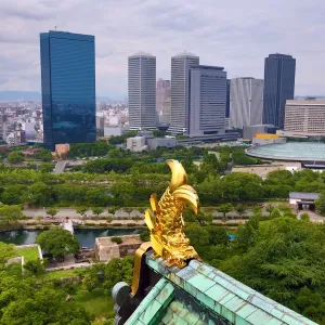 Golden fish roof decoration on Osaka Castle and city skyline, Osaka, Japan
