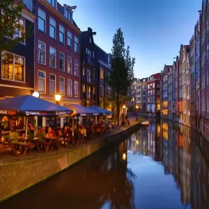 Houses and restaurants on the Oudezijds Achterburgwal canal at sunset in Amsterdam