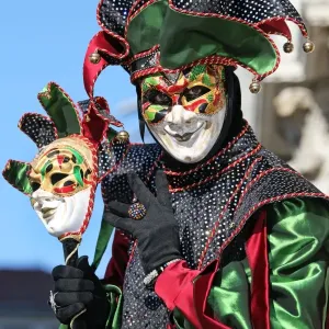 Man wearing a jester mask and costume at the Venice Carnival