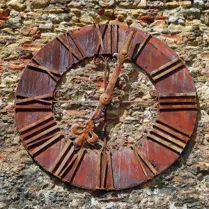 Old rusty clock on the wall beside Zagreb Cathedral in Zagreb, Croatia