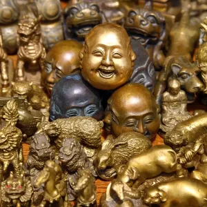 Pile of brass figures including laughing Buddha head in the Old City, Shanghai, China