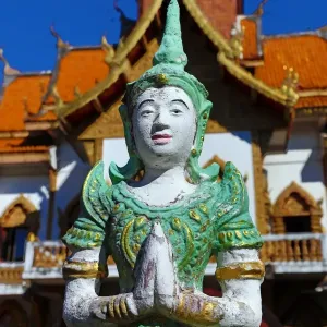 Praying statue in front of the ordination hall at Wat Buppharam Temple in Chiang Mai