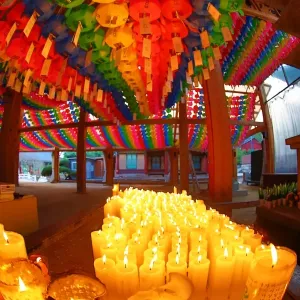 Rainbow coloured paper lanterns and candles at an altar in Bongeunsa Temple in Seoul