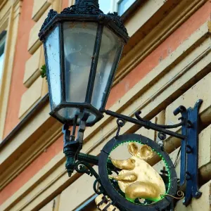 Street lamp and golden mouse sign for the Tlusta Mys (Fat Mouse), Prague, Czech Republic