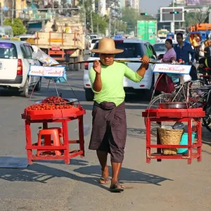 Street seller carrying wares on his shoulders, Yangon, Myanmar