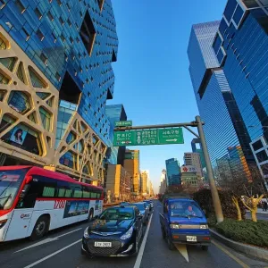 Traffic, tall modern buildings and office blocks at dusk in the Gangnam district