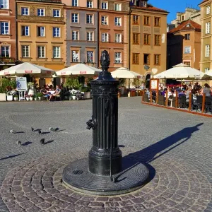 Water pump and traditional houses in the Old Town Market Place in Warsaw, Poland