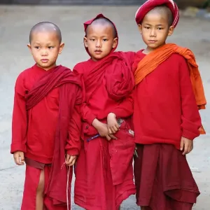 Three young Buddhist monks at a temple in Amarapura, Mandalay, Myanmar (Burma)