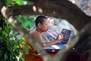 Luang Prabang, Laos: Buddhist monk reading a book at Vat Sop Sickharam temple, Luang Prabang, Laos