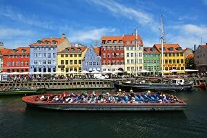 Coloured houses and a tourist sightseeing tour boat at Nyhavn Quay in Copenhagen, Denmark