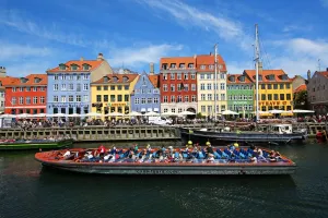 Tourism: Coloured houses and a tourist sightseeing tour boat at Nyhavn Quay in Copenhagen, Denmark