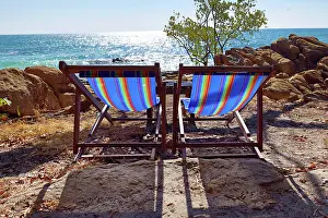 Tourism: Deckchairs on Koh Samet beach overlooking the sea on Koh Samet island, Thailand