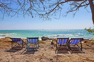 Tourism: Deckchairs on Koh Samet beach overlooking the sea on Koh Samet island, Thailand