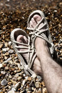 Beaches: Feet of a man wearing string holiday sandals