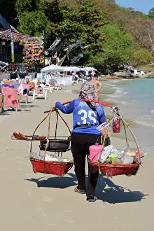 Scene: Food sellers carrying baskets on Phai Bay Beach on Koh Samet island, Thailand
