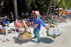 Scene: Food sellers carrying baskets on Sai Kaew Beach on Koh Samet island, Thailand