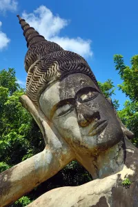 Laos: Grave markers and gold reclining sleeping Buddha statue at Wat Si Saket near Pha That Luang Temple