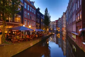 Amsterdam: Houses and restaurants on the Oudezijds Achterburgwal canal at sunset in Amsterdam