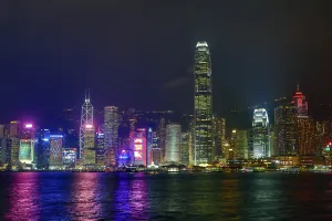 Tall: Lights of the city skyline of Central across Victoria Harbour at night in Hong Kong