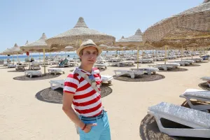 Beaches: Man on summer holiday on a beach full of umbrellas and sunshades