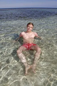 Beaches: Man on summer holiday relaxing and lying in the sea on the beach