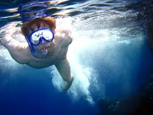 Pools: Man swimming on summer holiday diving wearing snorkelling mask